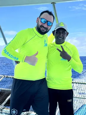 Friendly Maldives representative with a local fisherman on a boat in the open sea