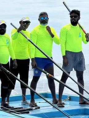 Local Maldivian fishermen posing on boat deck during traditional pole-and-line fishing