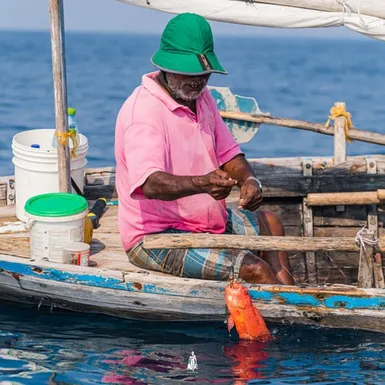 Fisherman sitting in a traditional Maldivian boat using pole and line method