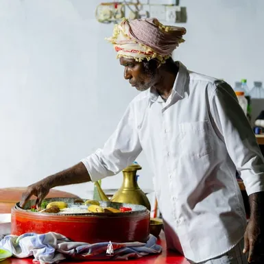 Maldivian chef serving traditional Mas huni made with tuna and coconut