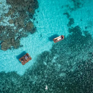 Maldivian boat floating above shallow coral reefs – highlighting low elevation and marine beauty